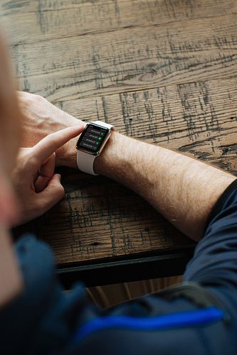 person wearing silver Apple Watch with white band